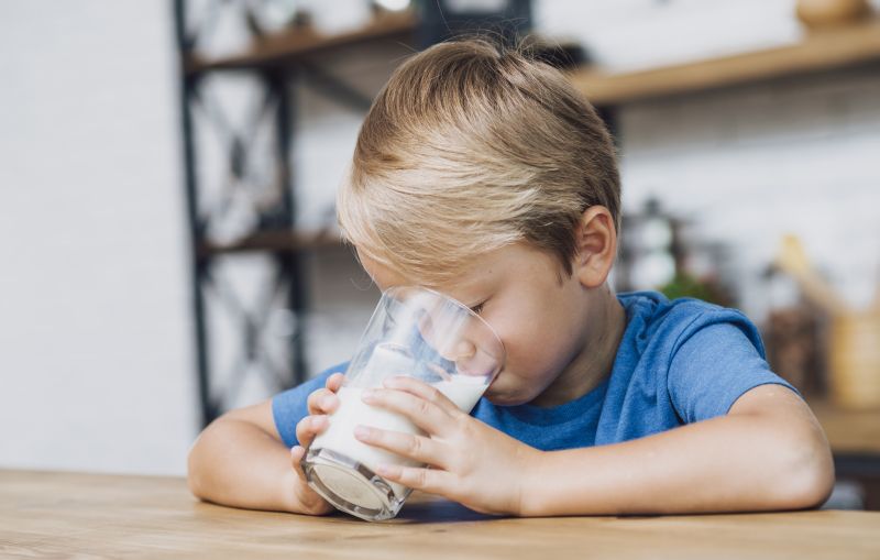 chlapec pijúci mlieko zo skleneného pohára