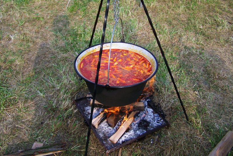 guláš varený v smaltovanom kotlíku na prenosným ohniskom