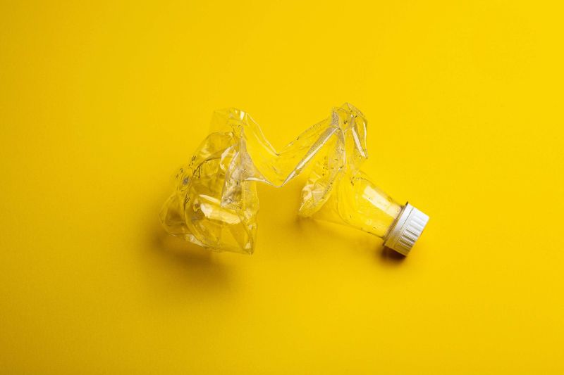 rozstrihnutá nadizajnovaná plastová fľaša na žltom podklade