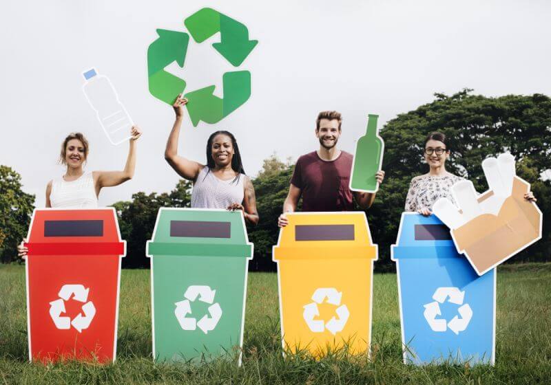 ľudia so znakmi recyklácie pre kov, sklo, papier a plast